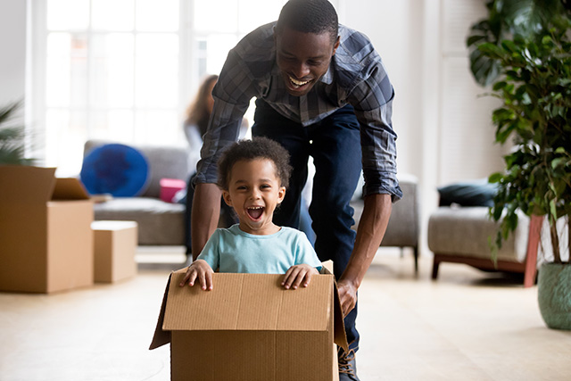 Dad pushing son in box through home