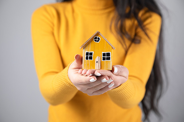 Woman holding home in her hands